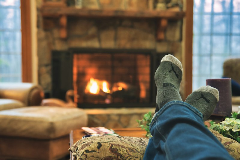 Feet in wool socks warming by a fireplace
